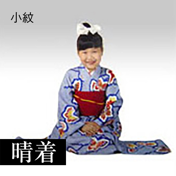 古い縮緬の着物を重ね着、手作りの太鼓を肩からさげています。口に縮緬の椿