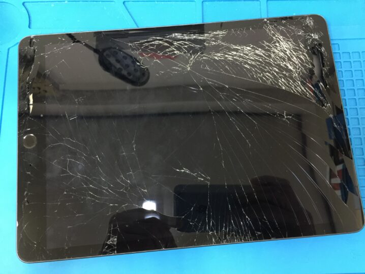 iPad 8 の画面が全体的にひび割れて破片が飛び散っている状態を