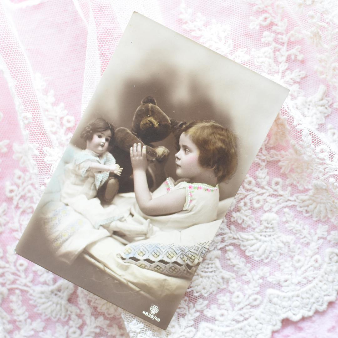 アンティークポストカード　お人形とテディベアとおしゃべりの可愛い少女　1912年