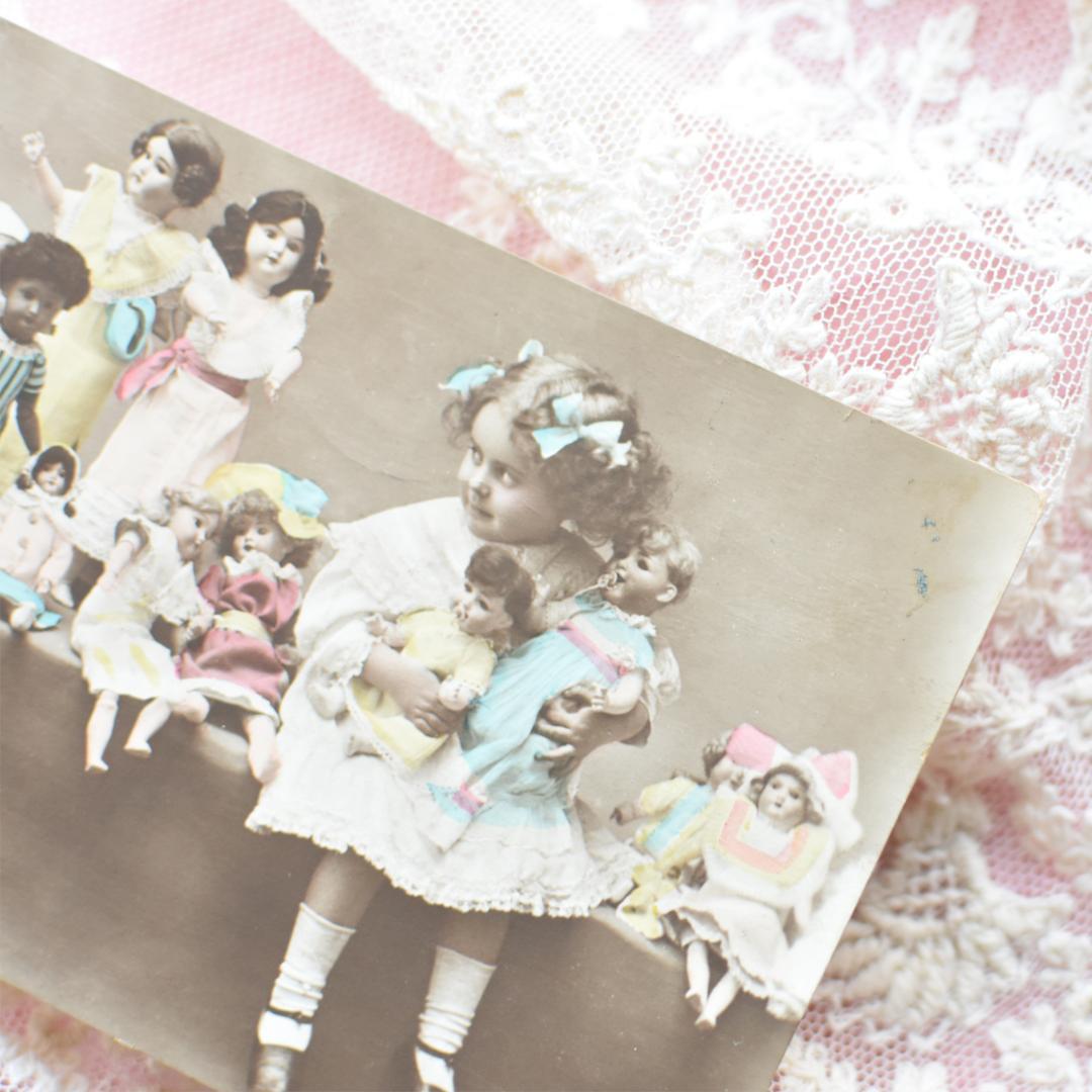 *アンティークポストカード　たくさんのお人形と愛らしい少女