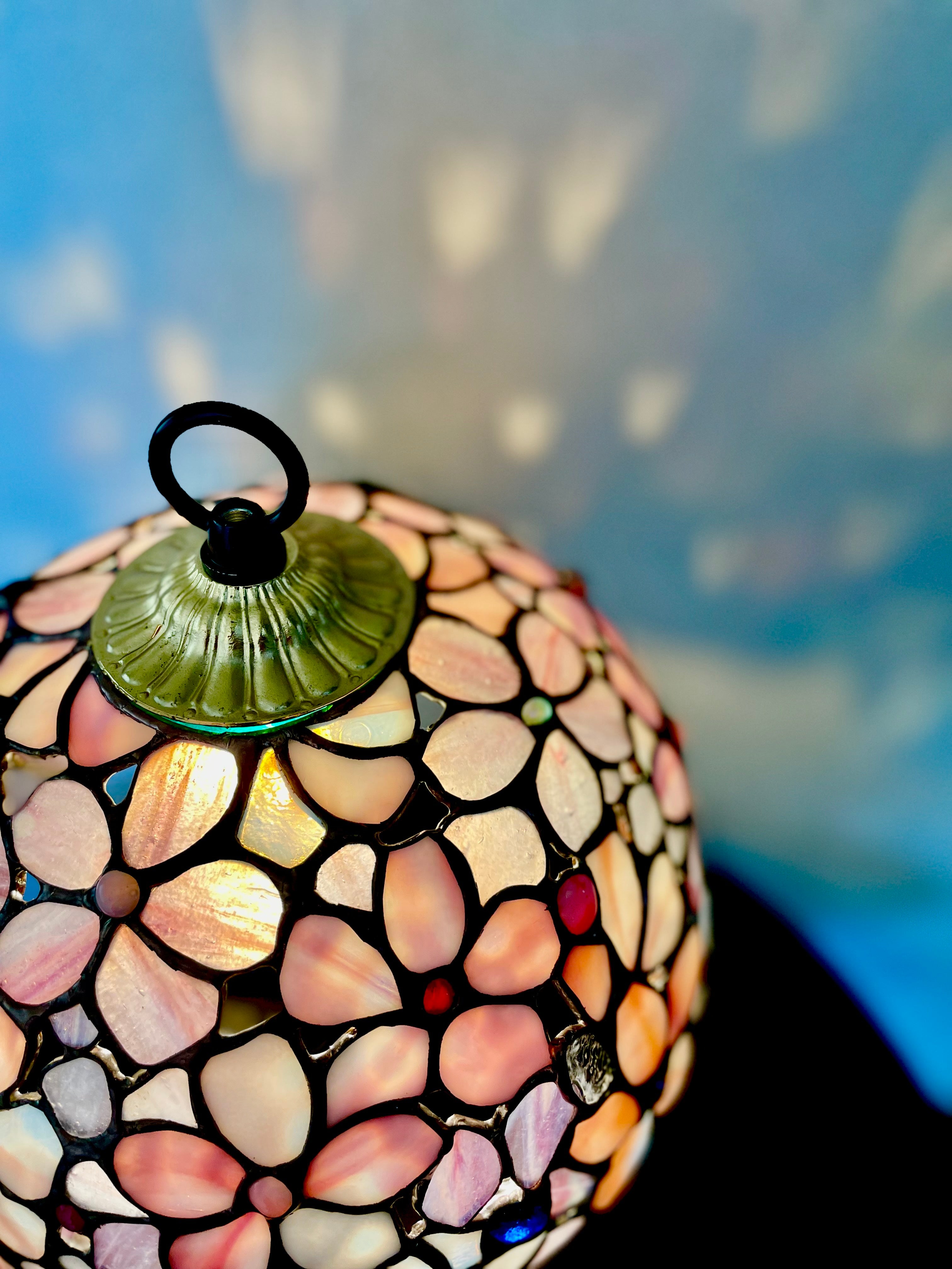 薔薇があでやかな大きなステンドグラス／宙に浮かぶ常夜灯がまるで